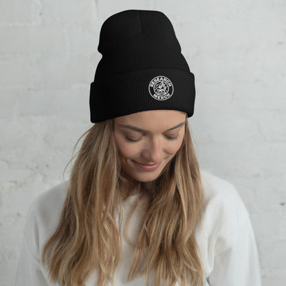 Schwarze gestrickte Beanie mit Research Merch Logo, getragen von einer Person mit langen Haaren, vor hellem Hintergrund.